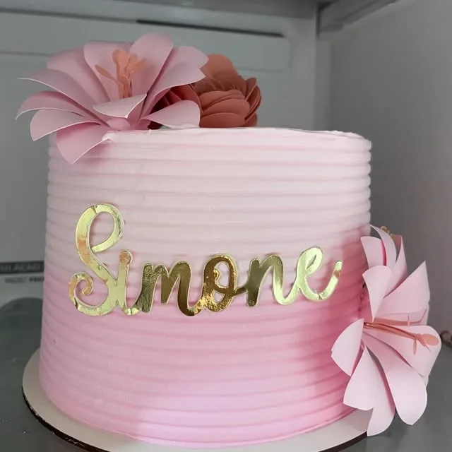 Bolo rosa frisado com flores de papel e nome dourado